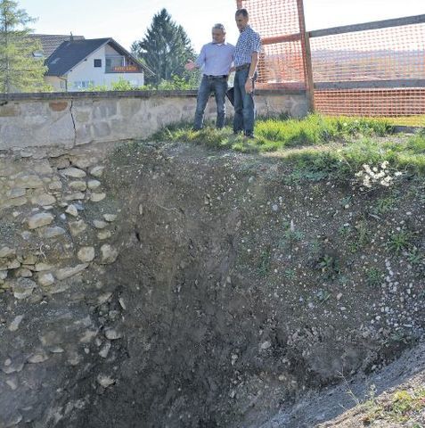 Marco Hasler (Architekt) und Franz Rutzer (Kirchgemeinde) schauen auf den Grund der Stützmauer der Kirche Eggenwil. Bild: BBA 17.10.2017/rwi