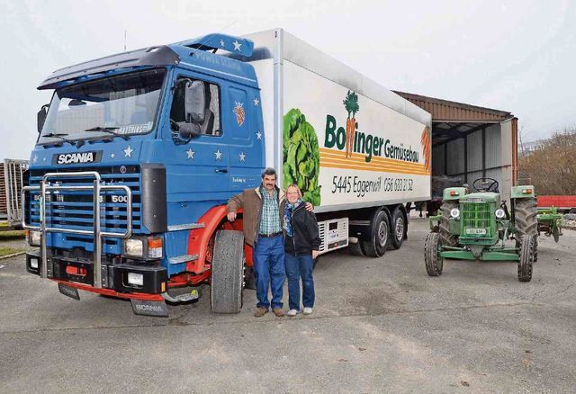 Matthias und Vroni Bollinger posieren vor zwei ihrer Schätze, dem 500-PS-Scania und dem (unverkäuflichen) 85-PS-Bührer. Bild: AZ 11.01.2018/Christian Breitschmid