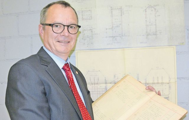 100 Jahre Elektra Eggenwil: Gemeinderat Frank Bonnemeier zeigt das Rechnungsbuch und die Pläne des Trafohäuschens. Bild: BBA 29.11.2019/Roger Wetli