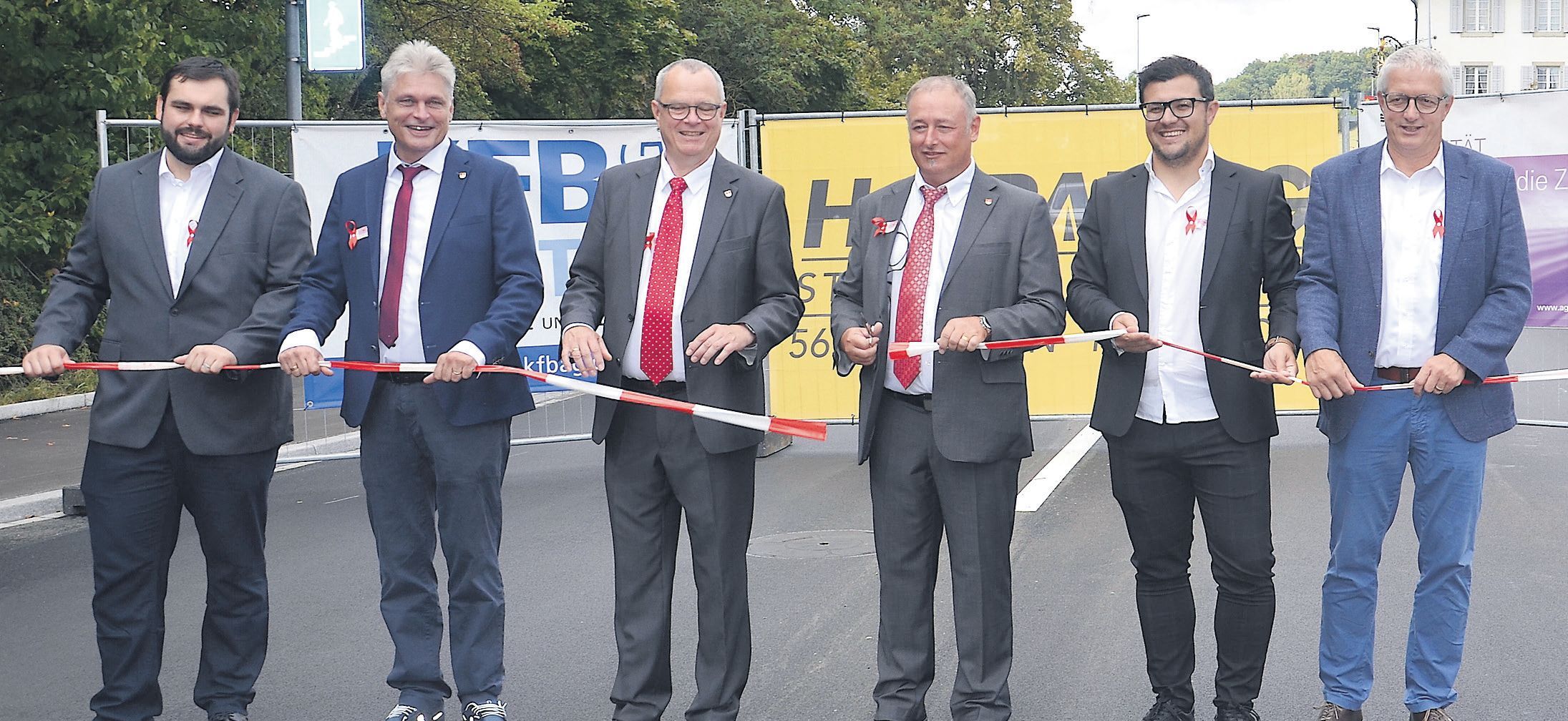 In einem symbolischen Akt gaben die Hauptinvolvierten die Strasse den Benutzern frei: (von links) Juraj Welte (Bauleiter KFP Pfister AG), Walter Bürgi (Gemeindeschreiber und Leiter Bau & Planung), Frank Bonnemeier (Gemeinderat, Ressortvorsteher Verkehr und Gemeindewerke), Roger Hausherr (Gemeindeammann, Ressortvorsteher Bau und Planung), Elmin Jelecevic (Oberbauleiter Abteilung Tiefbau Kt. Aargau) und Dieter Schaub (Geschäftsführer und Bauführer der H. Graf AG). Bild: BBA 30.08.2022/Erika Obrist