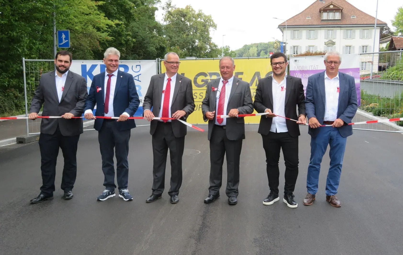 Juraj Welte (Bauleiter KFP Pfister AG), Walter Bürgi (Gemeindeschreiber und Leiter Bau & Planung), Frank Bonnemeier (Gemeinderat, Ressortvorsteher Verkehr und Gemeindewerke), Roger Hausherr (Gemeindeammann, Ressortvorsteher Bau und Planung), Elmin Jelecevic (Oberbauleiter Abteilung Tiefbau Kt. Aargau) und Dieter Schaub (Geschäftsführer und Bauführer der H. Graf AG) zerschneiden das Band zur Einweihung der komplett sanierten Kantonsstrasse K 271 im Eggenwiler Innerort. Bild: AZ Freiamt 29.08.2022/Marc Ribolla