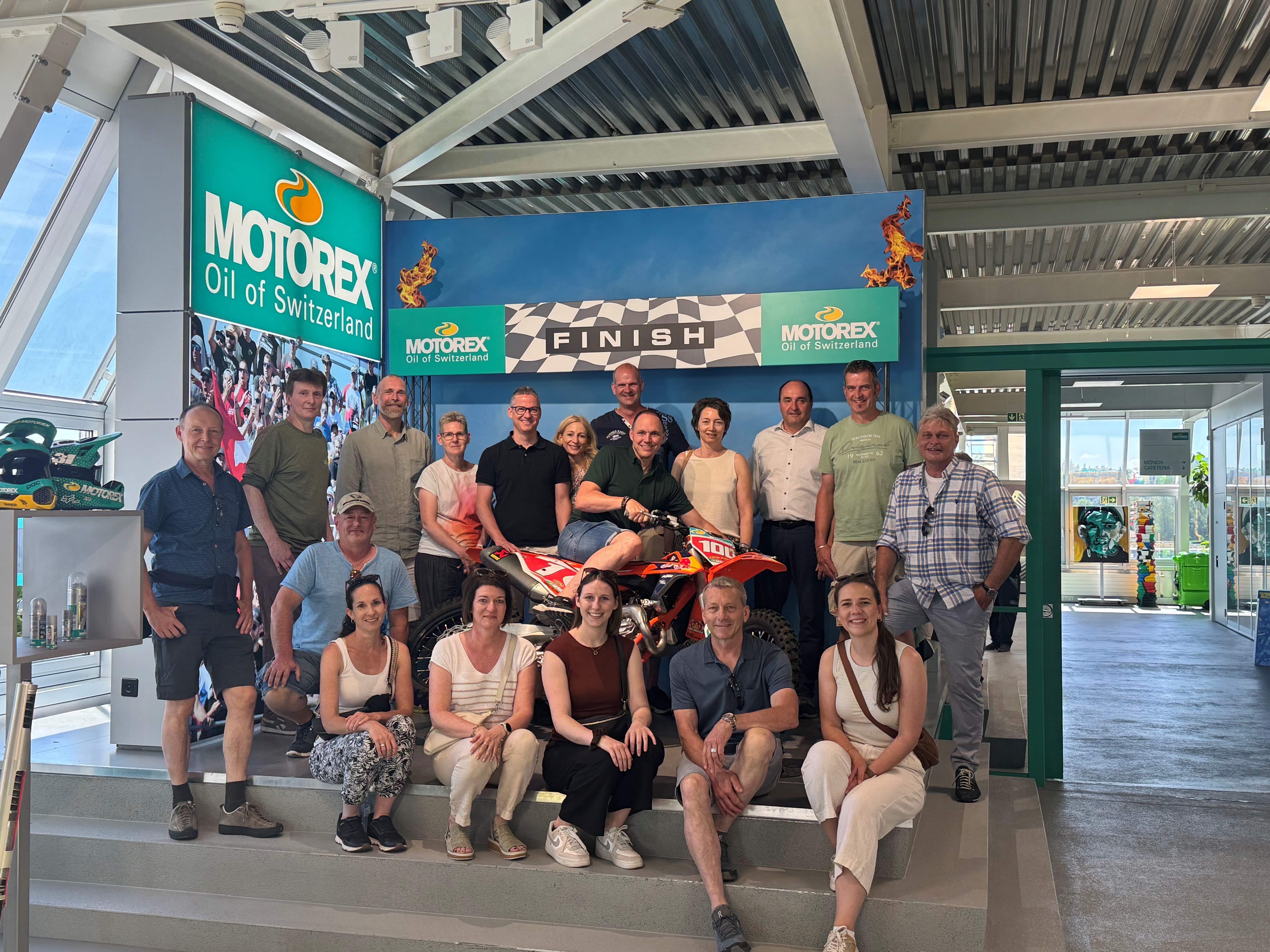 Die insgesamt 17 Teilnehmerinnen und Teilnehmer am diesjährigen Gemeinderats- und Verwaltungsausflug Eggenwil erhielten einen äusserst spannenden Einblick in die Firma MOTOREX AG in Langenthal BE – höchstpersönlich und mit enorm viel Fachkompetenz und Herzblut begleitet durch den Geschäftsführer Edi Fischer, der auch in Eggenwil wohnhaft ist. Bild: v.l. Ruedi Etter (Schulleiter), René Angst (ICT-Verantwortlicher), Roger Hausherr (Gemeindeammann bis Ende 2025), Sabrina Baudinot (Verwaltungsangestellte bis Ende 2025), Sebastian Meyer (Gemeinderat), Martina Egger (Leiterin Steuern), Gabi Renner (künftige Leiterin Finanzen), Nicola Altschul (Gemeinderat), Esther Werthmüller (Gemeinderätin), Vanessa Villars (Leiterin Finanzen), Markus Belser (Stv. Leiter technische Dienste), Pascal Vogel in der Mitte auf dem Motorrad (Gemeindeammann), Sylvia Koch (Schulverwalterin und Verwaltungsangestellte), Bruno Meier (Leiter technische Dienste), Edi Fischer (Geschäftsführer MOTOREX AG), Roland Belser (Vizeammann), Rahel Wismer (Leiterin Einwohnerdienste und Soziale Dienste) sowie Gemeindeschreiber und Verwaltungsleiter Walti Bürgi. Bild: Motorex AG/29.05.2026