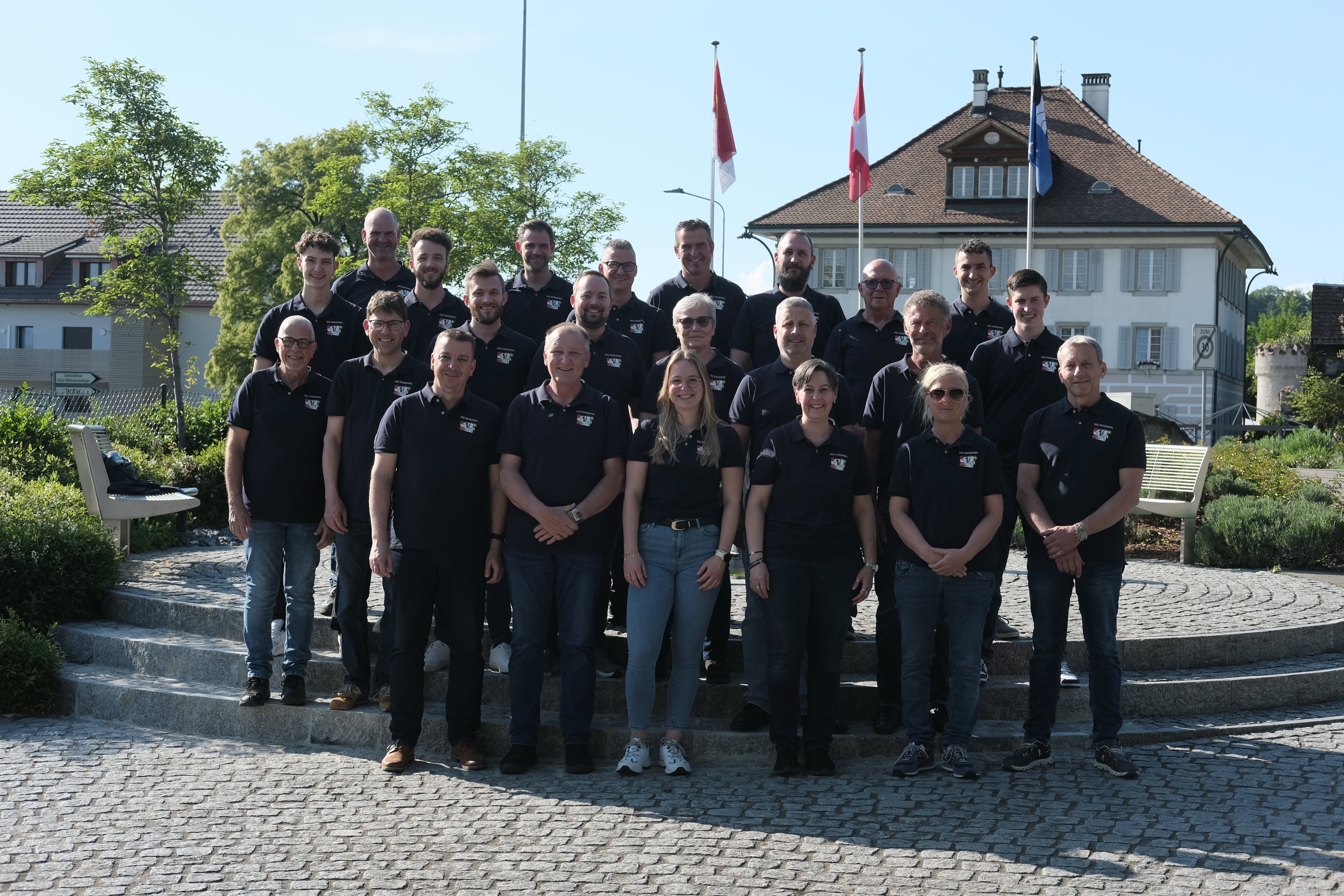 Die Musikgesellschaft Eggenwil heisst die Bevölkerung herzlich willkommen und freut sich auf ein unvergessliches Jubiläumsfest 2026. Bild: Michelle Altschul, Gruppenfoto MG Eggenwil vom 08.05.2026 auf dem Dorfplatz Eggenwil